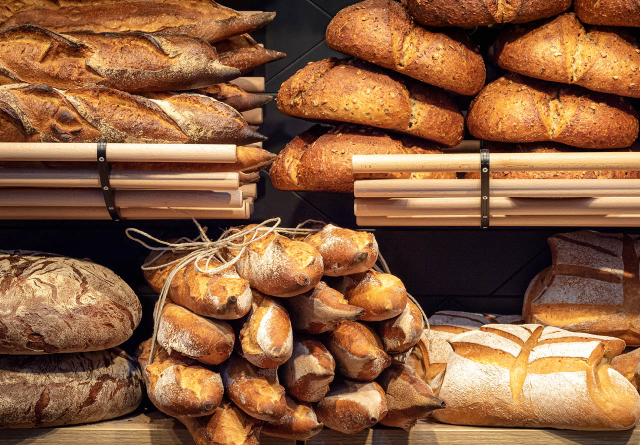Loaves of bread on wooden shelves in baker shop, in Germany. Different types of bread. Tasty sourdough bread. Healthy eating. Bakery interior.